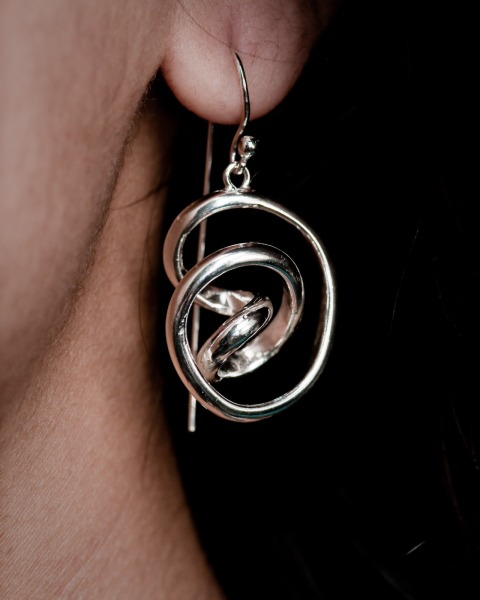 Silver wire earring being worn